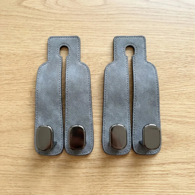Two BOLTHUT leather headrest hooks laid out
