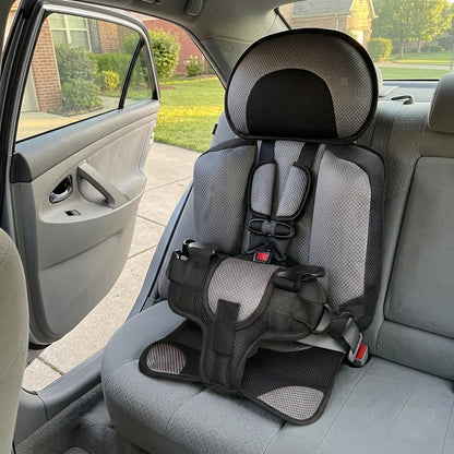 Portable travel car seat installed in a sedan back seat