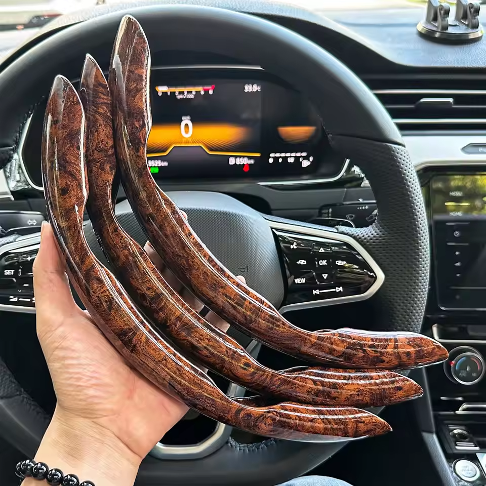 Wooden car interior trim pieces held in front of a car dashboard.