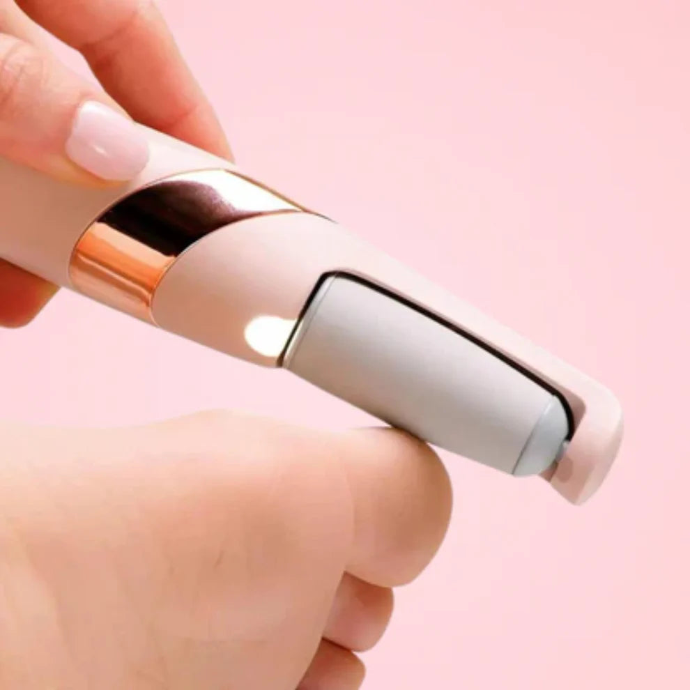 Hand holding a small electronic device with a rose gold and white design on a pink background