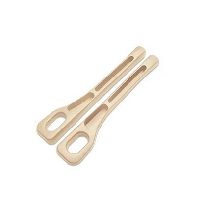 Two beige metal tongs on a white background