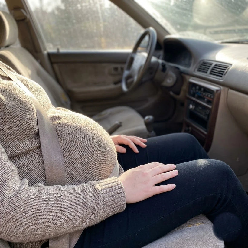 Lap belt riding up across a pregnant belly before the adjuster