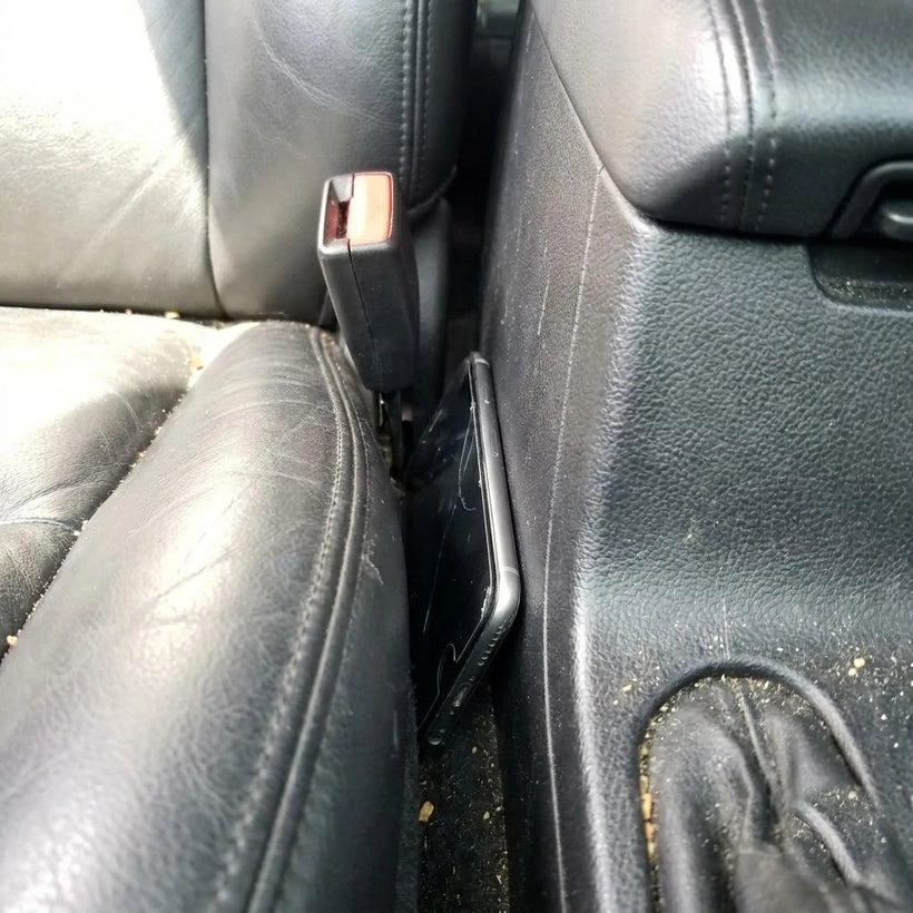 Coins and a phone lost in an open car seat gap